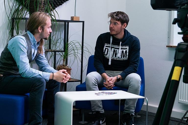 Zwei Mnner sitzend an einem kleinen Tisch im ZLF-Studio 