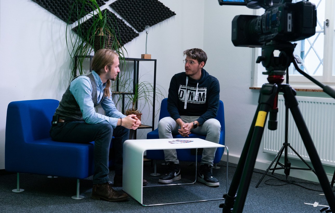 Zwei Personen sprechen in der Diskussionsecke ZLF-Studio vor einer Kamera