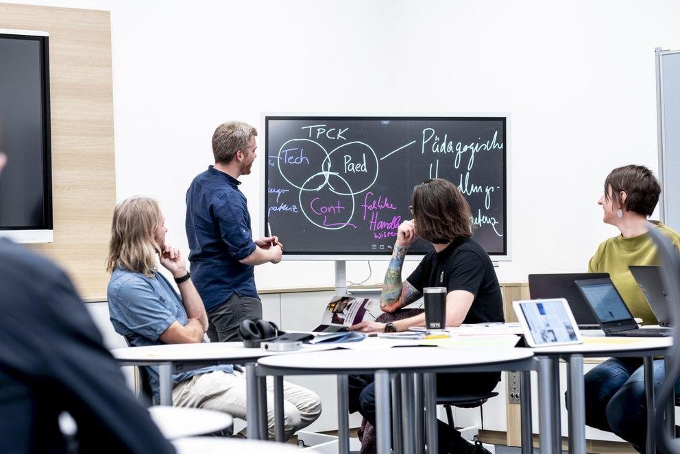 Menschen besprechen Bildungsthemen an einem Whiteboard