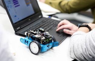 Ein Roboter steht neben einem Laptop