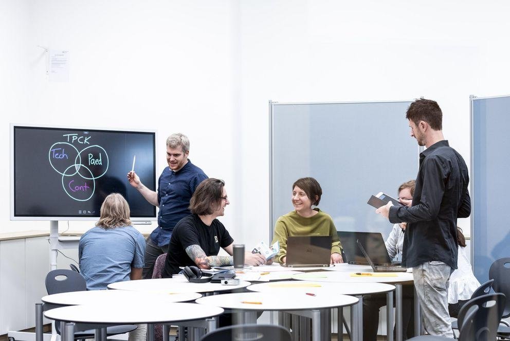 Coworking in der Lehrkräftebildung Foto zeigt eine Gruppe an Menschen die nach Coworking Prinzip arbeiten.